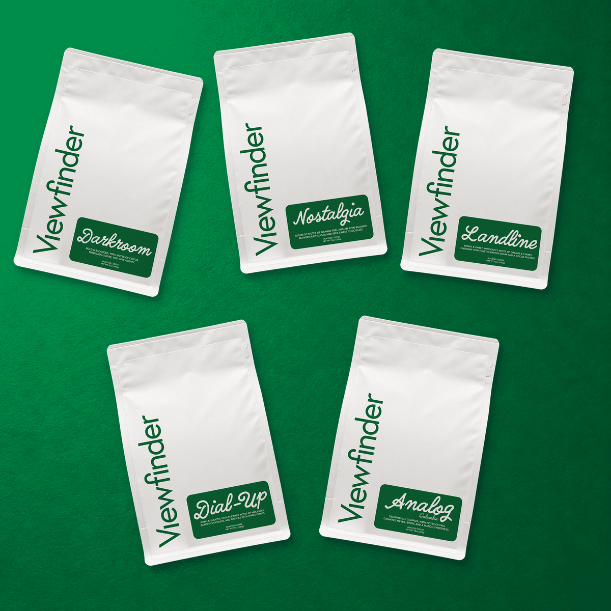Five Viewfinder Essentials coffee bags: Darkroom, Nostalgia, Landline, Dial-Up, and Analog, arranged on a green background